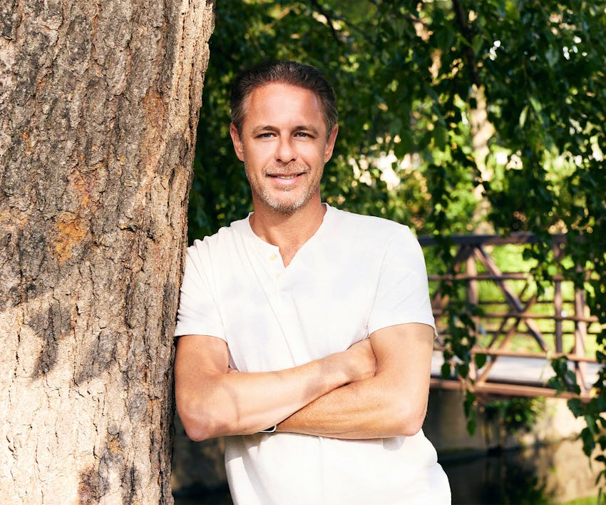 Man leaning against tree