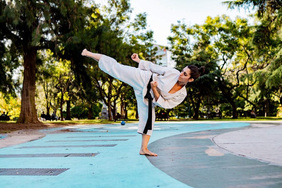 Black belt woman doing a karate kick with hip injury