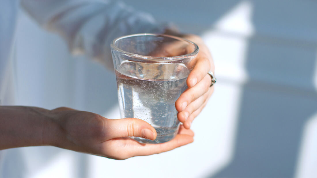 Holding a glass of water with both hands