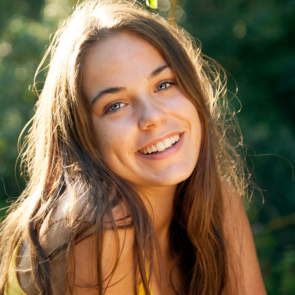 Younger model with brown hair smiling