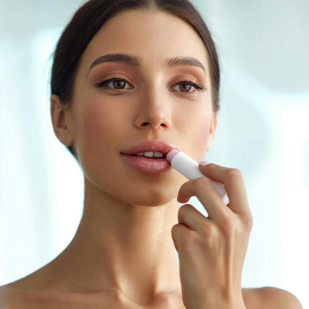 woamn putting lipstick on