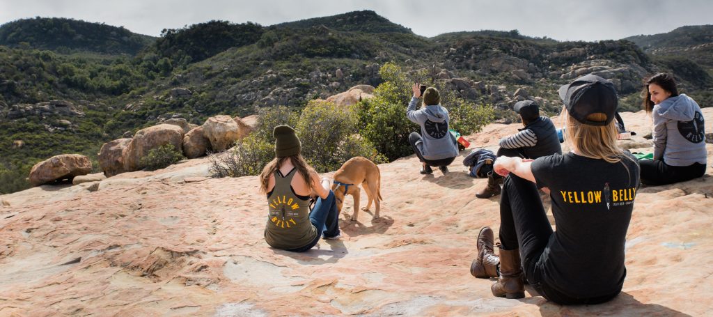 Image of people in Yellow Belly t-shirts sitting down together