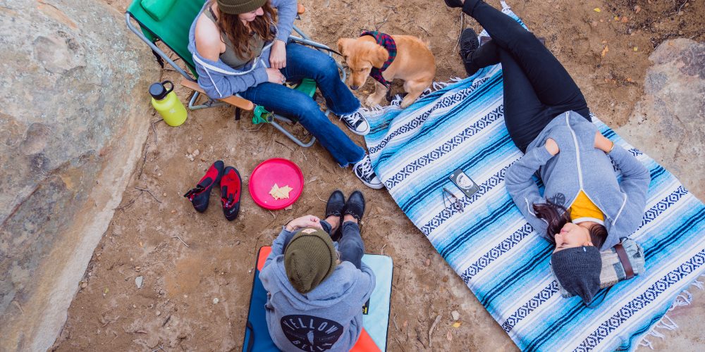 Image of three people sitting and wearing Yellow Belly merch