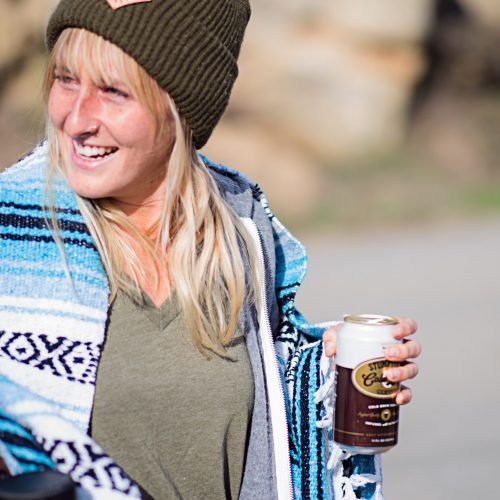 Image of a girl drinking a beer wearing Yellow Belly merchandise