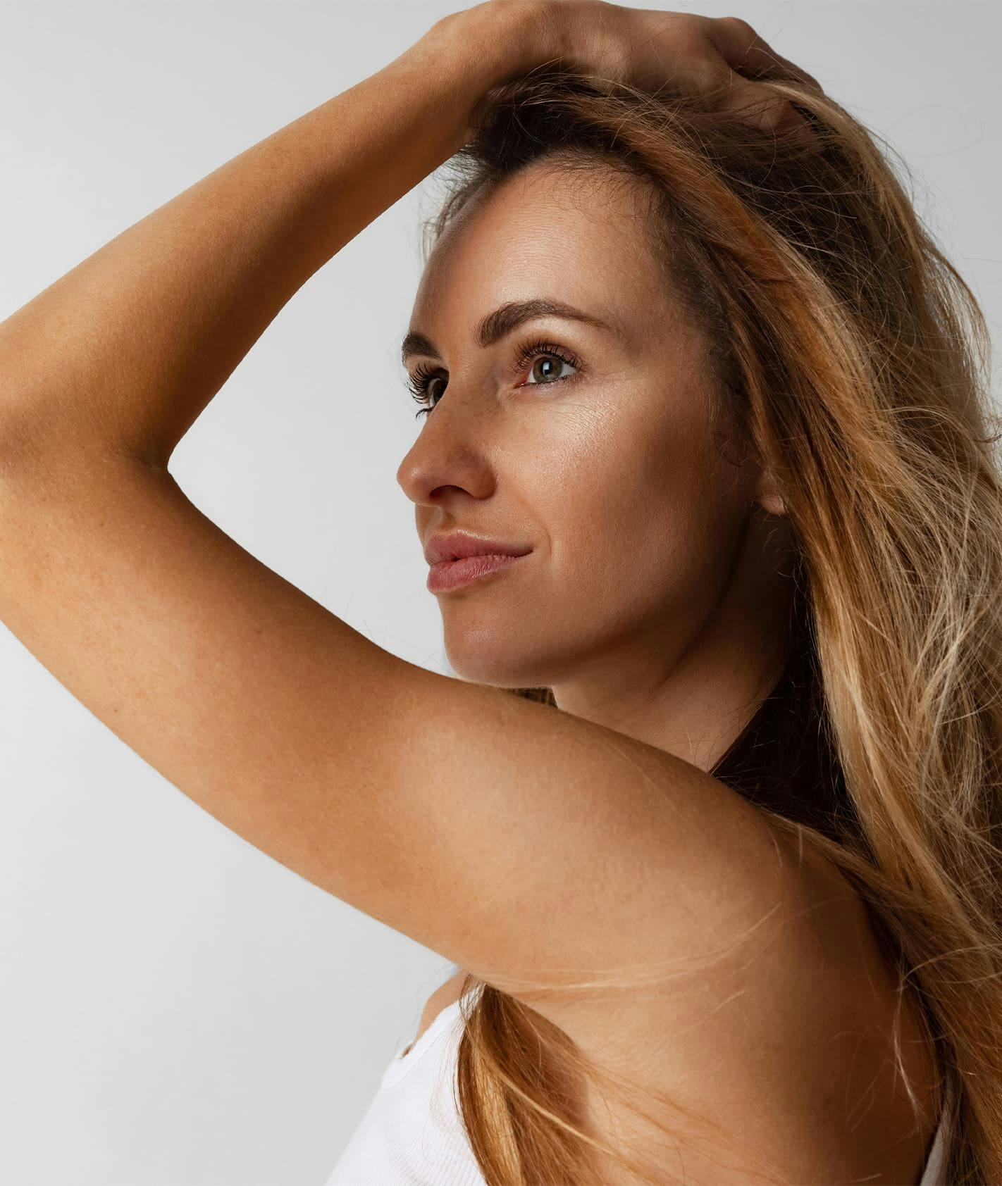 Woman smiling with hand in hair