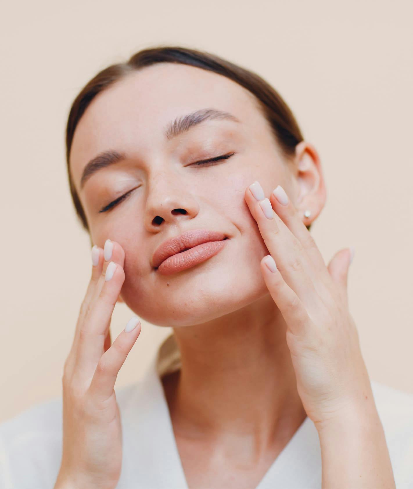 Woman touching face with eyes closed