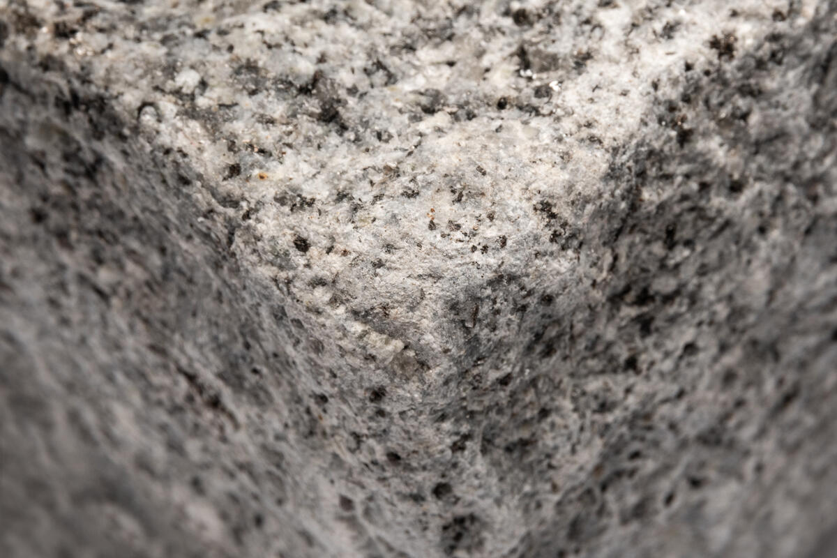 Close up of a medium grey tumbled granite sett