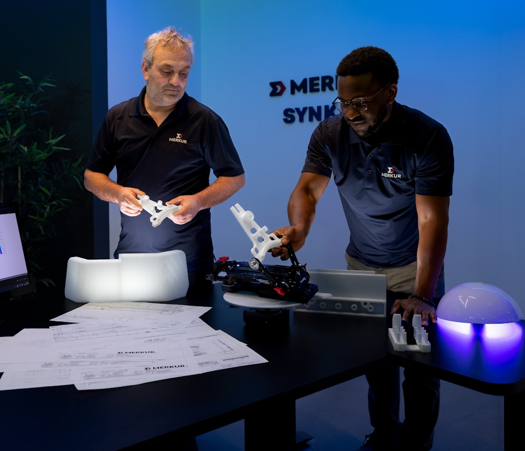 Deux hommes discutent devant un prototype