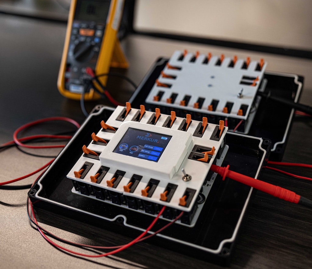 Module électronique de contrôle avec multimètre numérique en arrière plan.