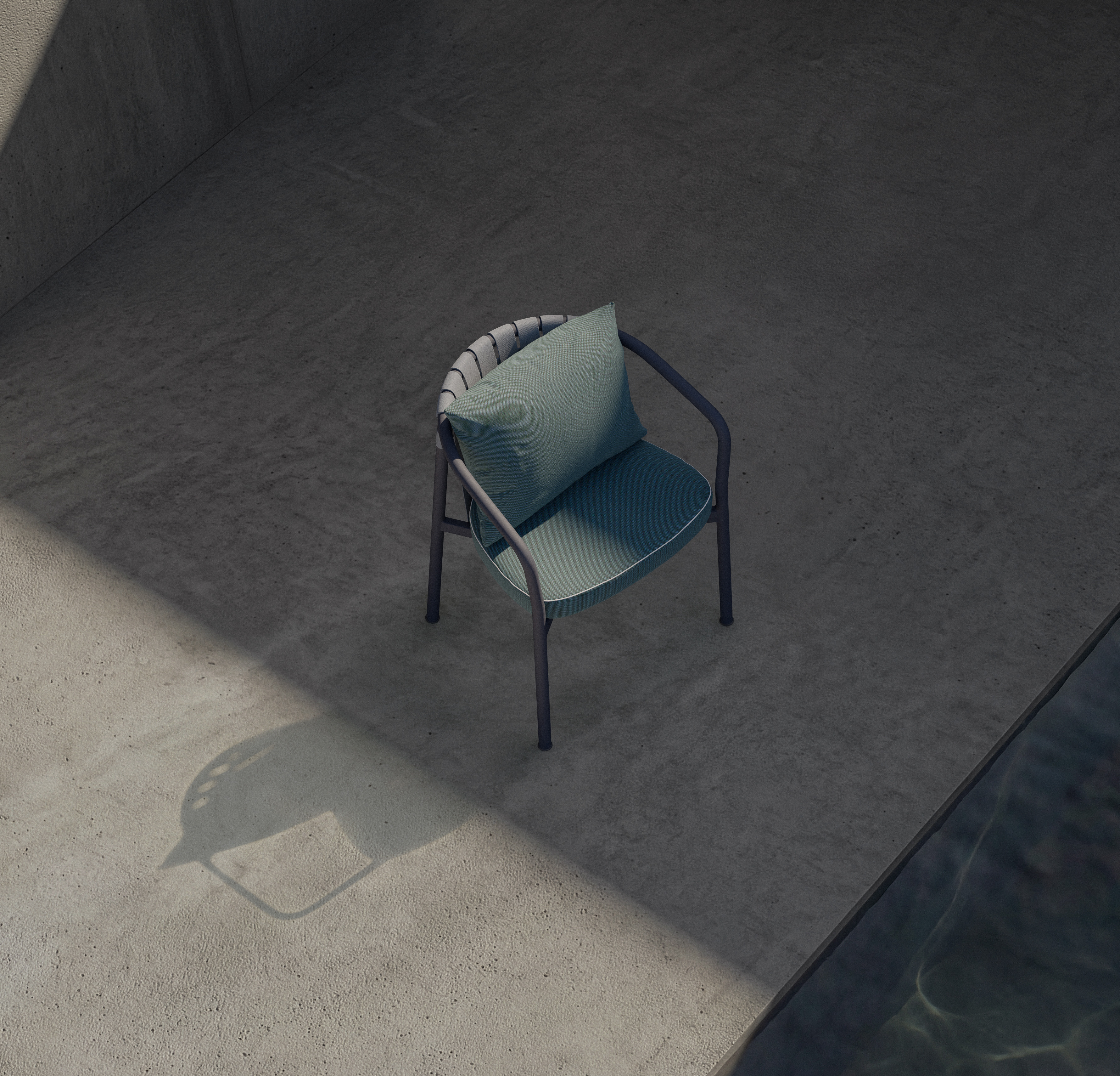 A single modern chair with blue cushions sits on a concrete floor beside a pool. Sunlight casts a shadow of the chair, and the scene is minimalistic and serene.