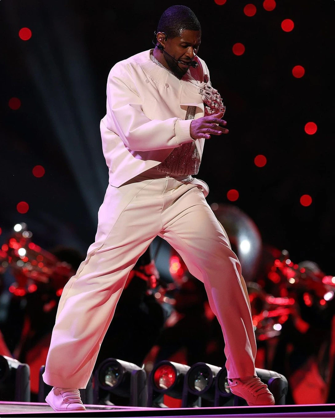Usher dances in white suit red lighting at Super Bowl Halftime Show