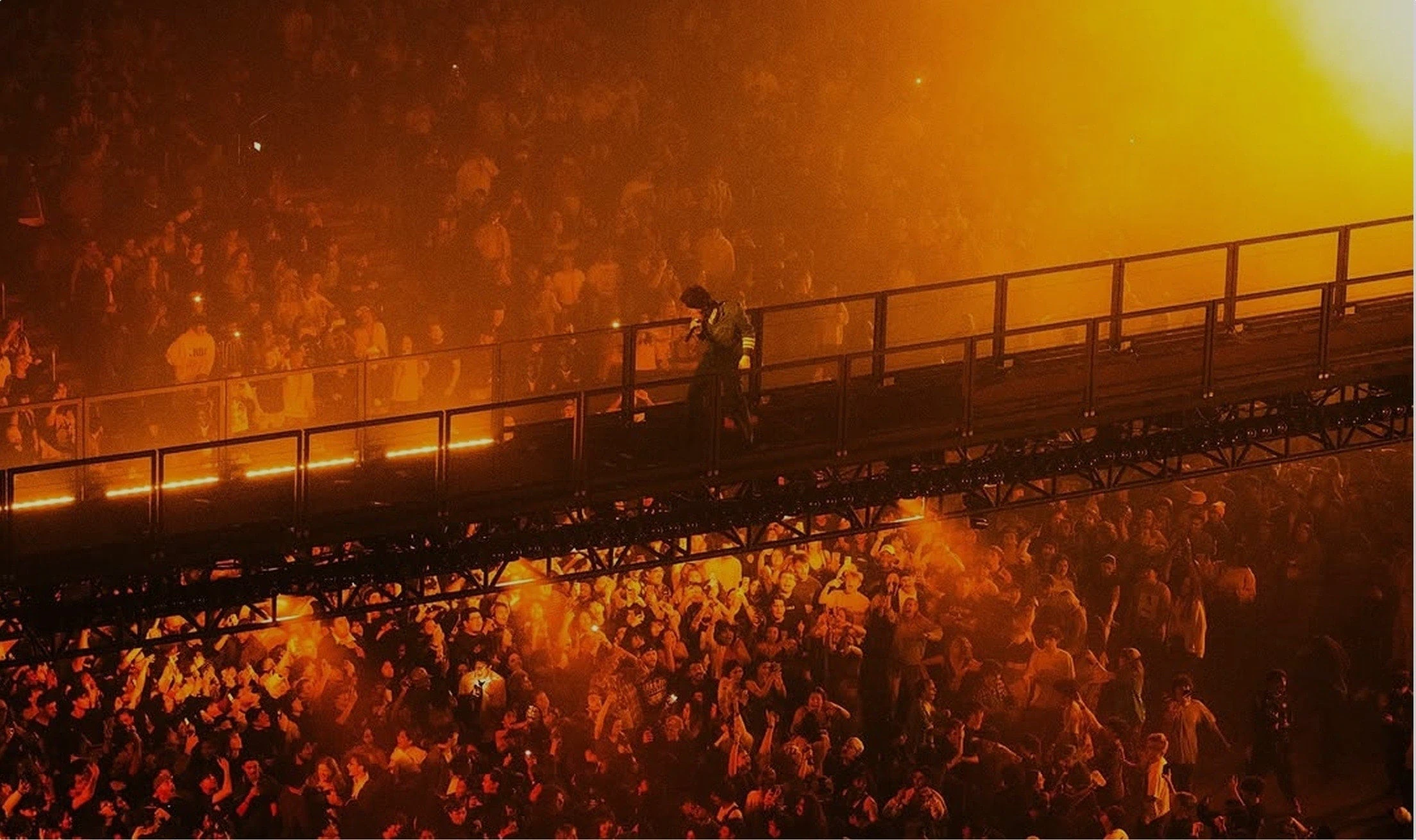 Tyler, The Creator - CHROMAKOPIA Tour - Silent House - Photo by Shaun Llewellyn Bridge set designed by Silent House for Tyler, The Creator during his CHROMAKOPIA Tour. Shot from above audience below amber light