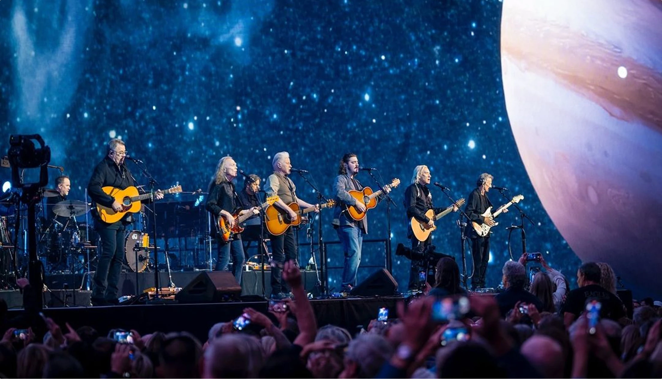The Eagles perform on-stage at Sphere Las Vegas during their residency with space planet star content behind them