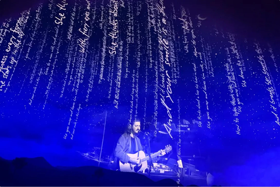 Text falls from top of screen as The Eagles perform at Sphere Las Vegas under blue haze light