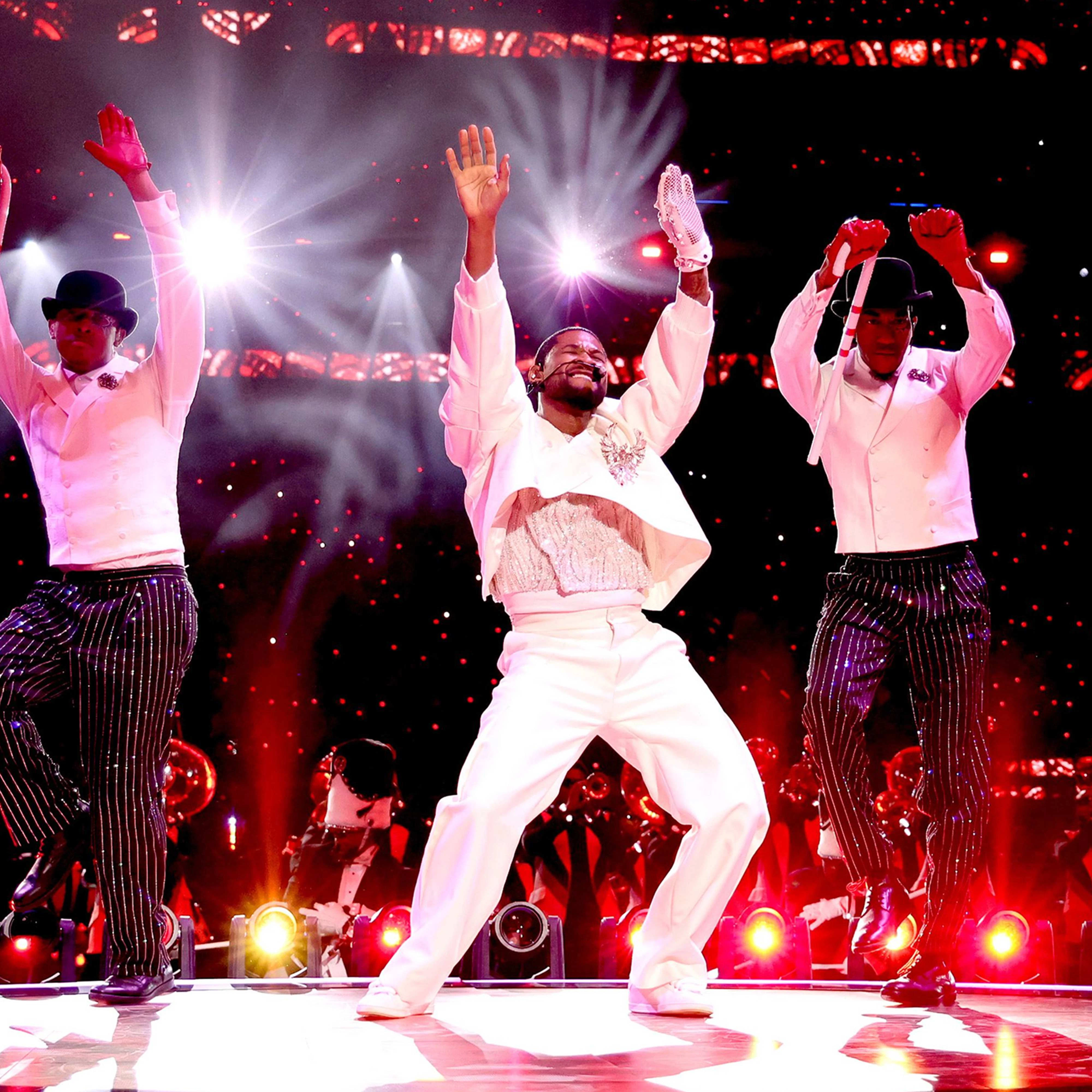Usher Super Bowl Halftime Show Usher and two dancers perform on-stage at the SuperBowl Halftime Show LVIII in white suits red lights