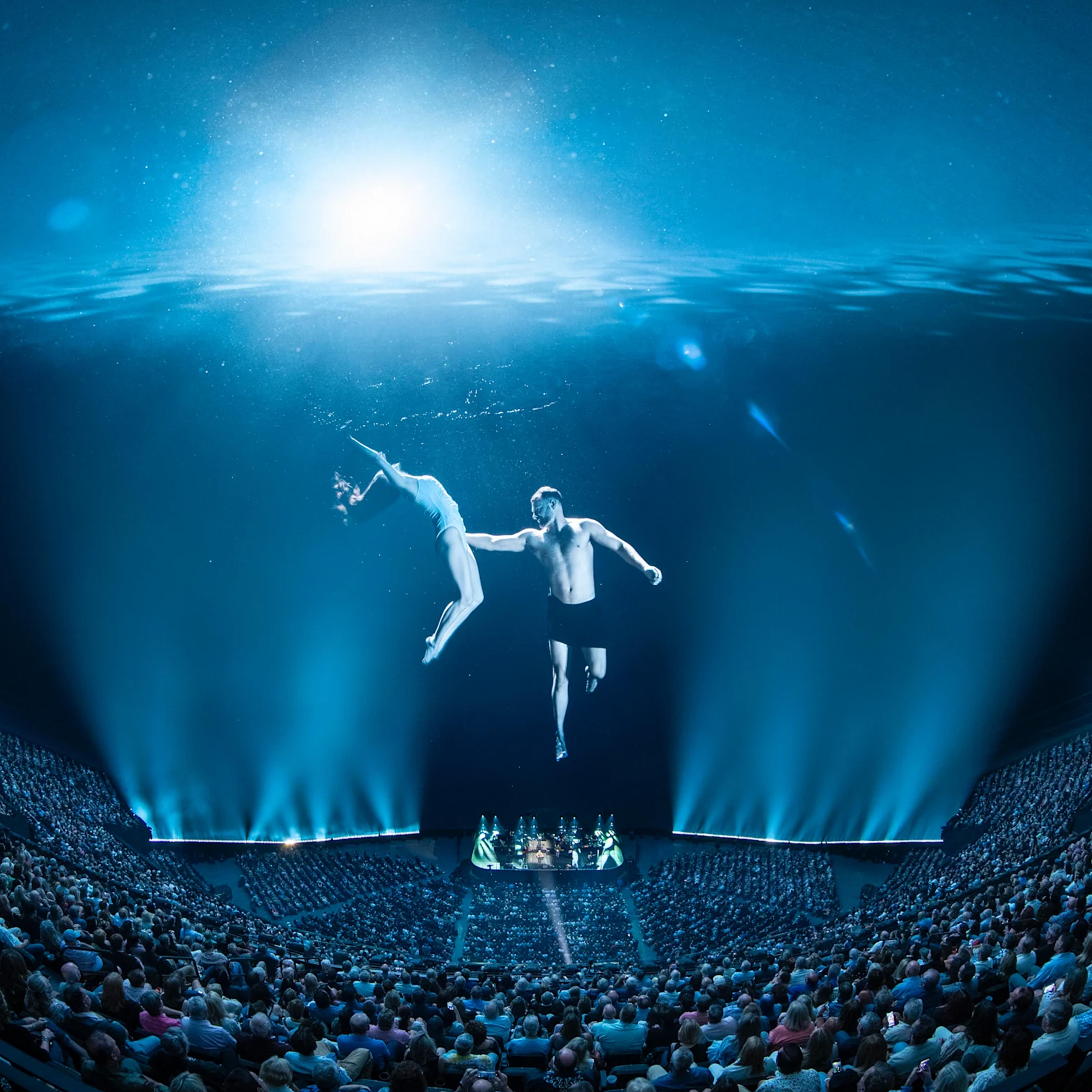 Dancers underwater graceful pose content blue lighting at Sphere Las Vegas