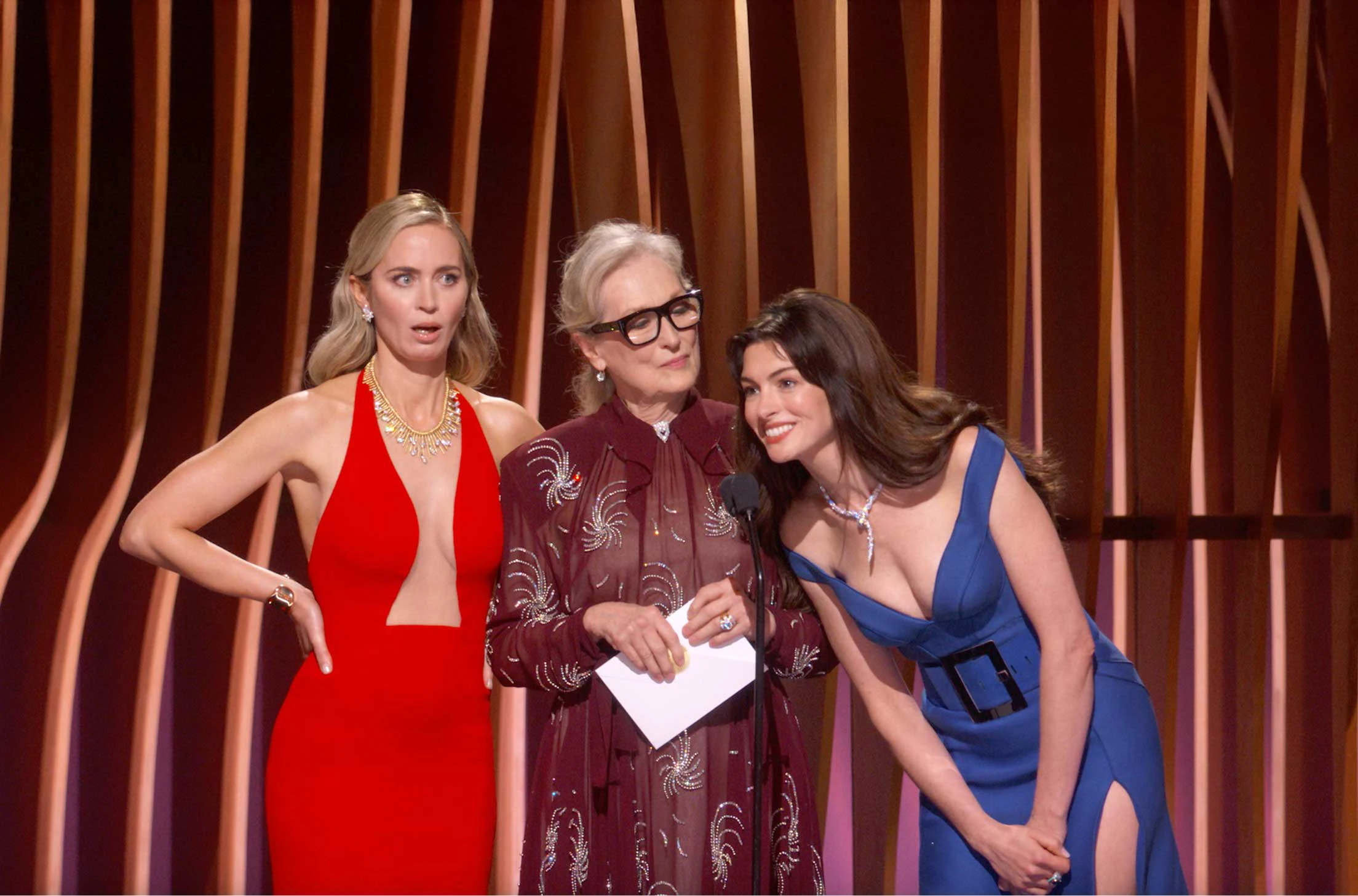 The cast of The Devil Wears Prada, Emily Blunt, Meryl Streep, and Anne Hathaway reunite on stage at the 30th SAG Awards. Emily Blunt wearing a red dress, Meryl Streep wearing glasses and holding the envelope, Anne Hathaway wearing a cerulean dress