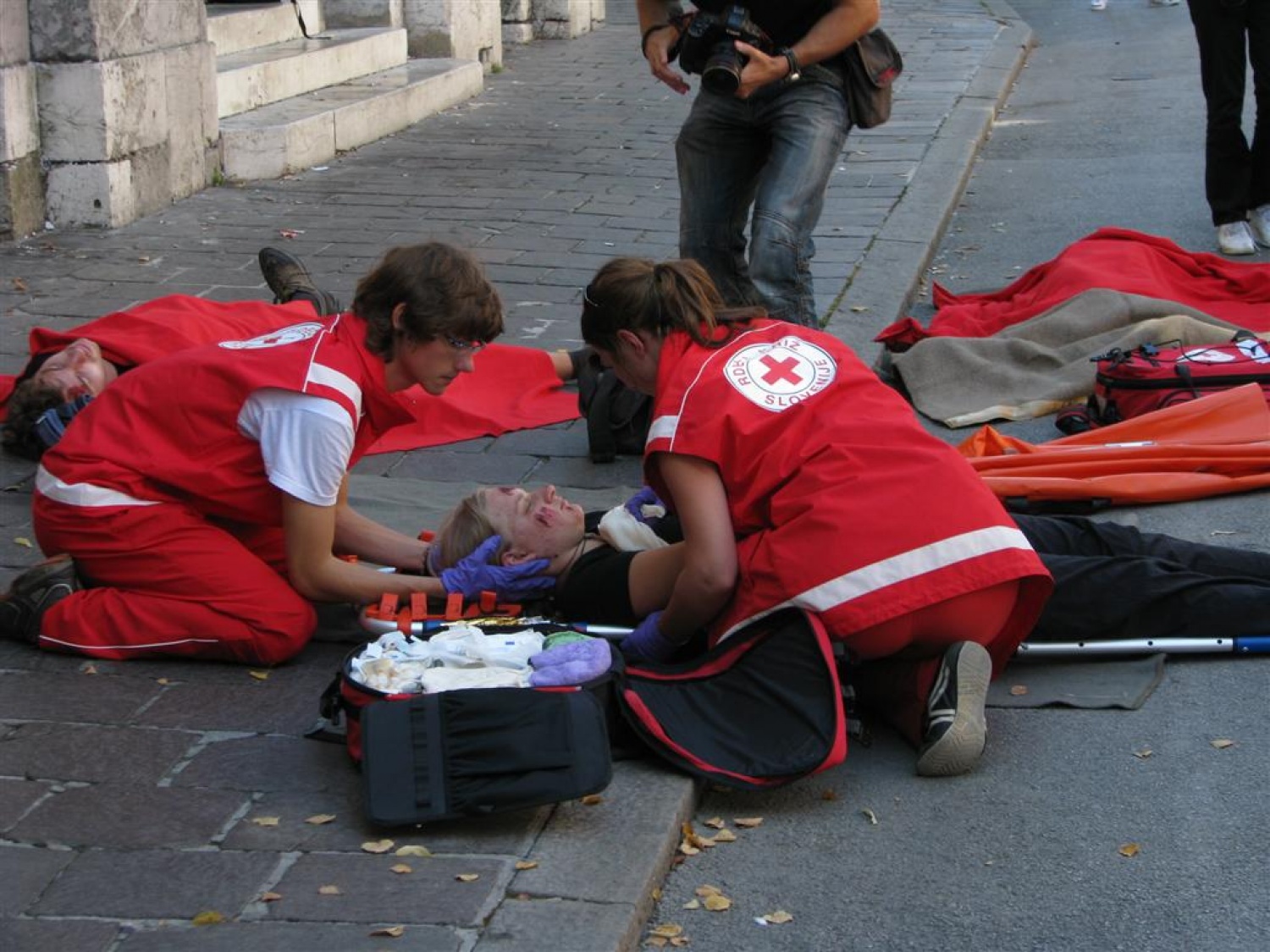 Masovna nesreča. Dva kombija polna ljudi, nekateri močno poškodovani, drugi lažje ranjeni, nekaj samo pijanih. Pritečeta dve skupini reševalcev, ekipa skavtov in ekipa Rdečega križa in začneta reševati življenja. Tokrat je šlo samo za vajo.