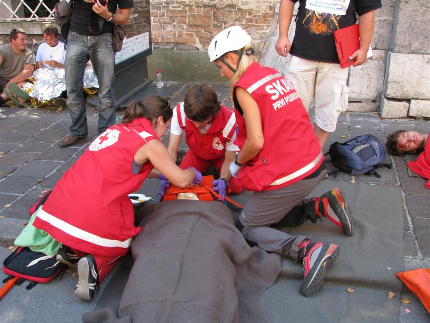 Masovna nesreča. Dva kombija polna ljudi, nekateri močno poškodovani, drugi lažje ranjeni, nekaj samo pijanih. Pritečeta dve skupini reševalcev, ekipa skavtov in ekipa Rdečega križa in začneta reševati življenja. Tokrat je šlo samo za vajo.