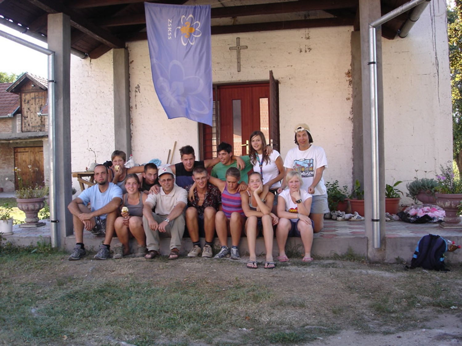 Pred našo bazo, pod zastavo, desno od smetnjaka.