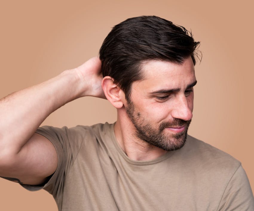 man touching the back of his head