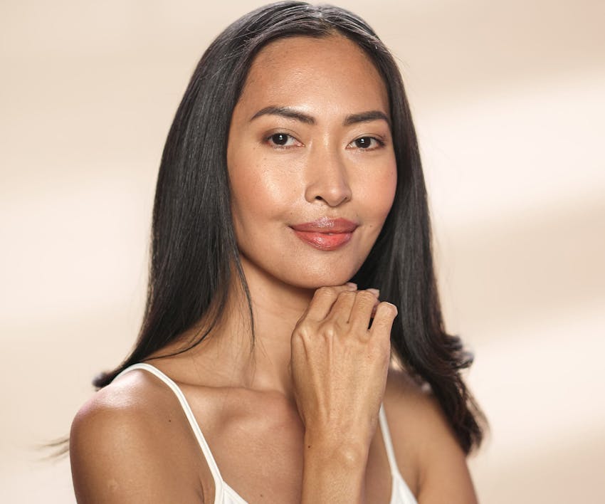 Woman smiling while touching chin