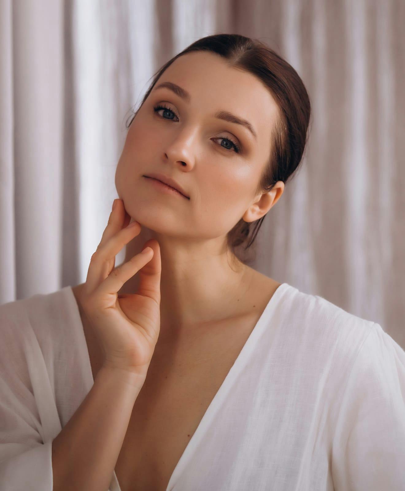 Woman tilting her head, with a hand to her neck