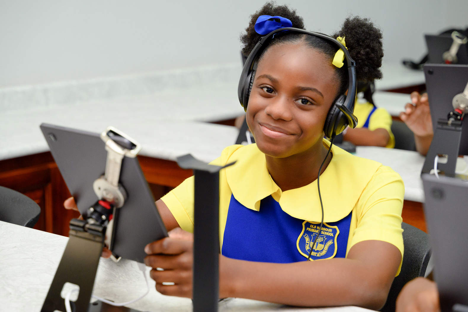 Smiling girl wearing headphones and holding a tablet