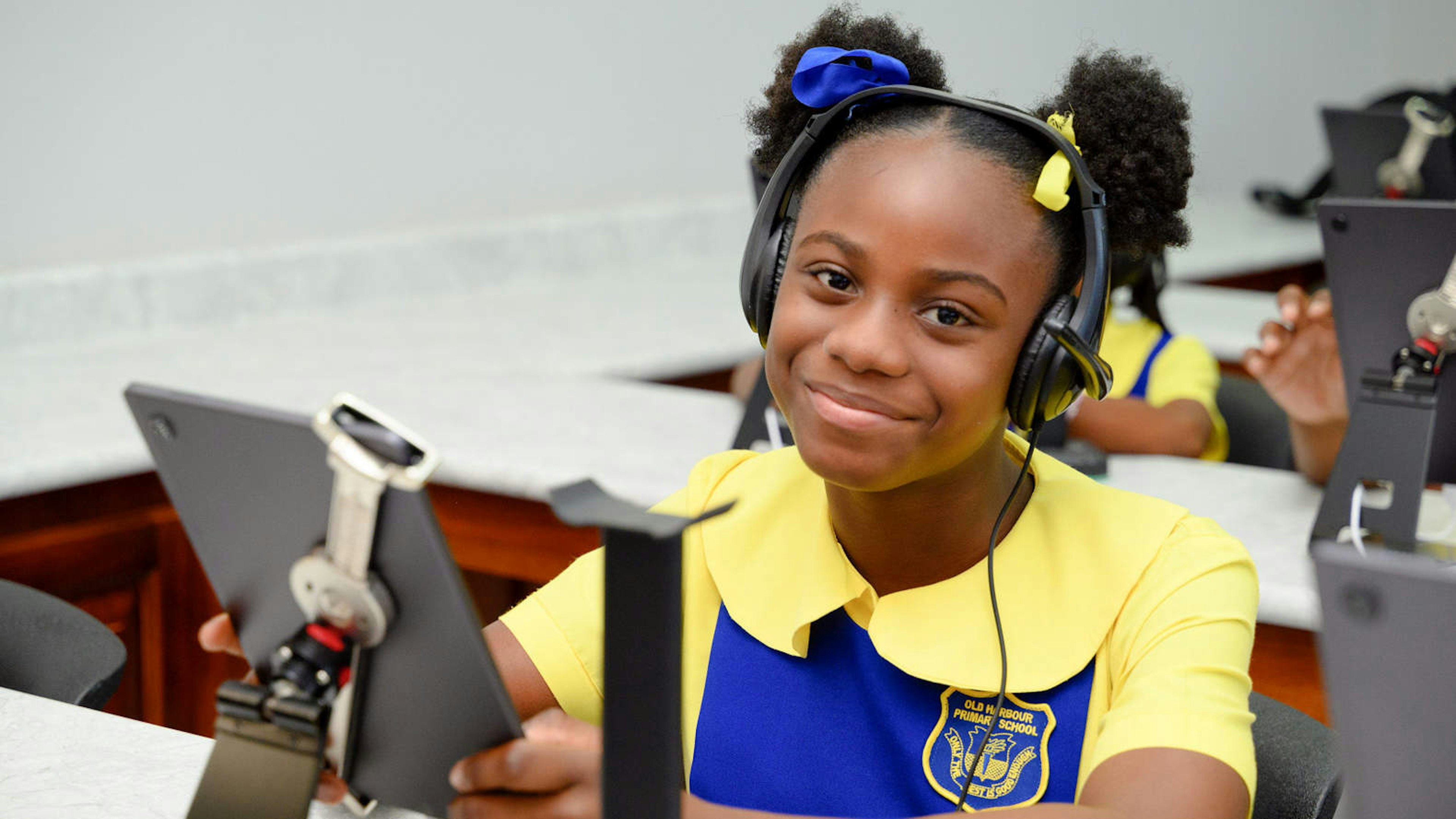 Smiling girl wearing headphones and holding a tablet