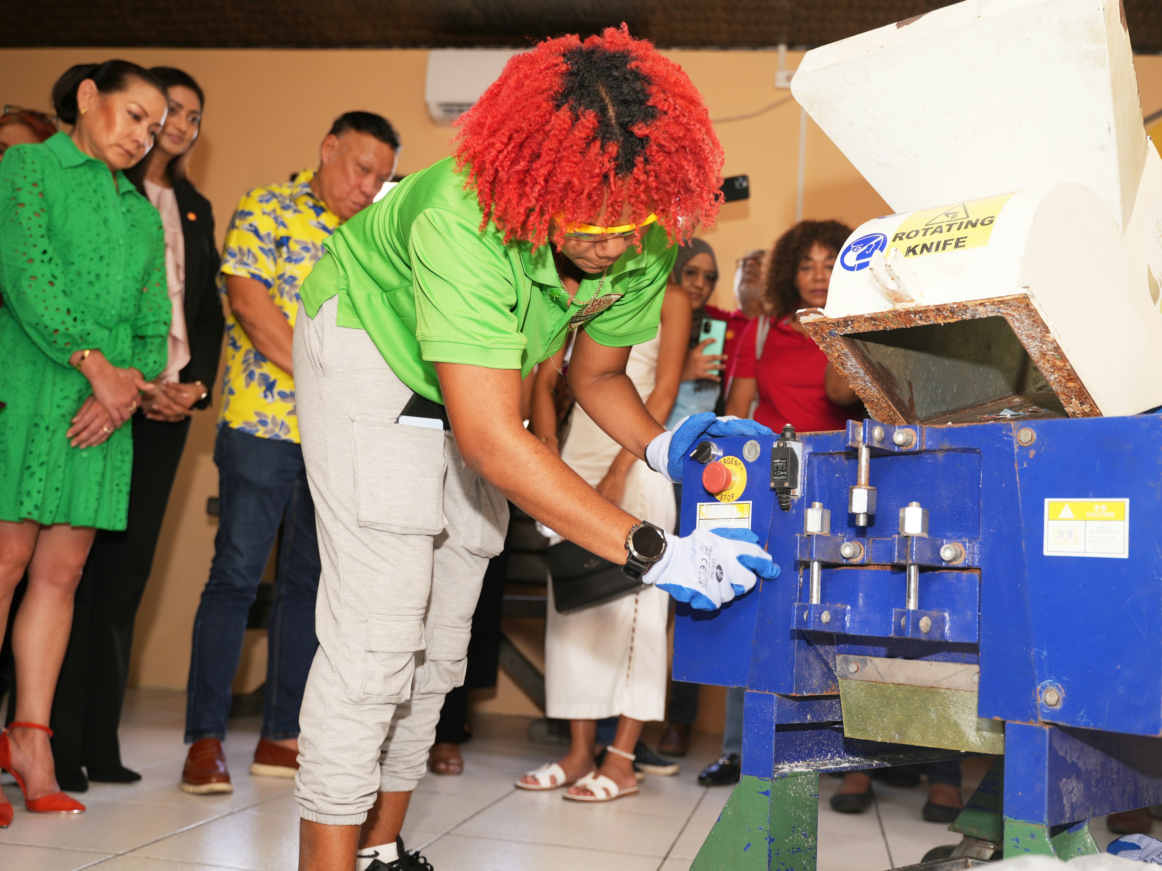 Girl using machine to shred plastic