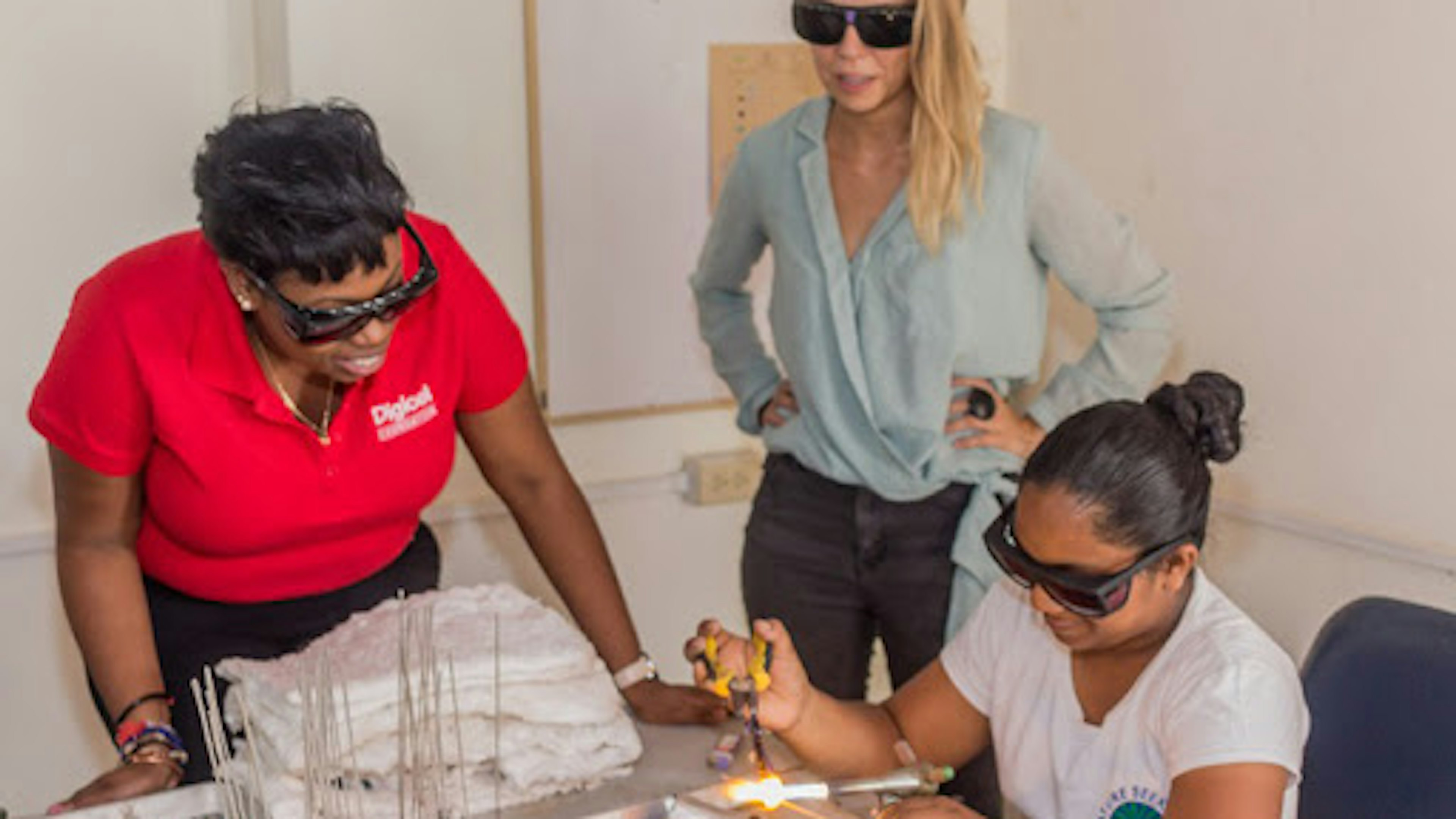 Three women making glass craft