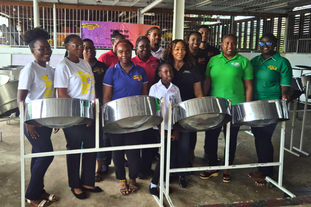 Pannists pose by steel pans with Digicel Foundation