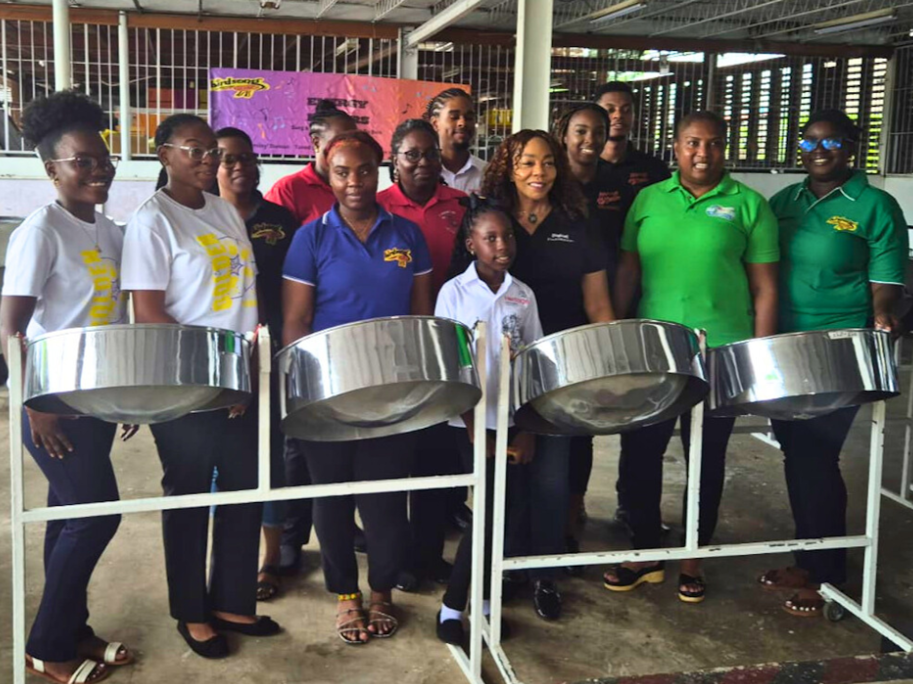 Pannists pose by steel pans with Digicel Foundation