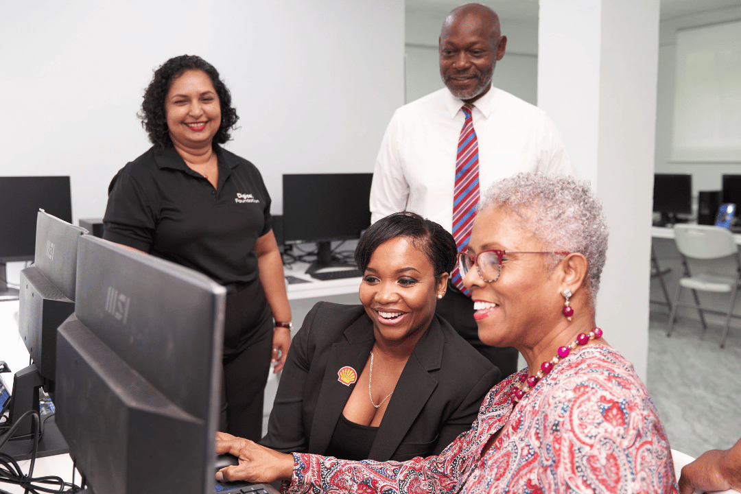 four people looking at a computer
