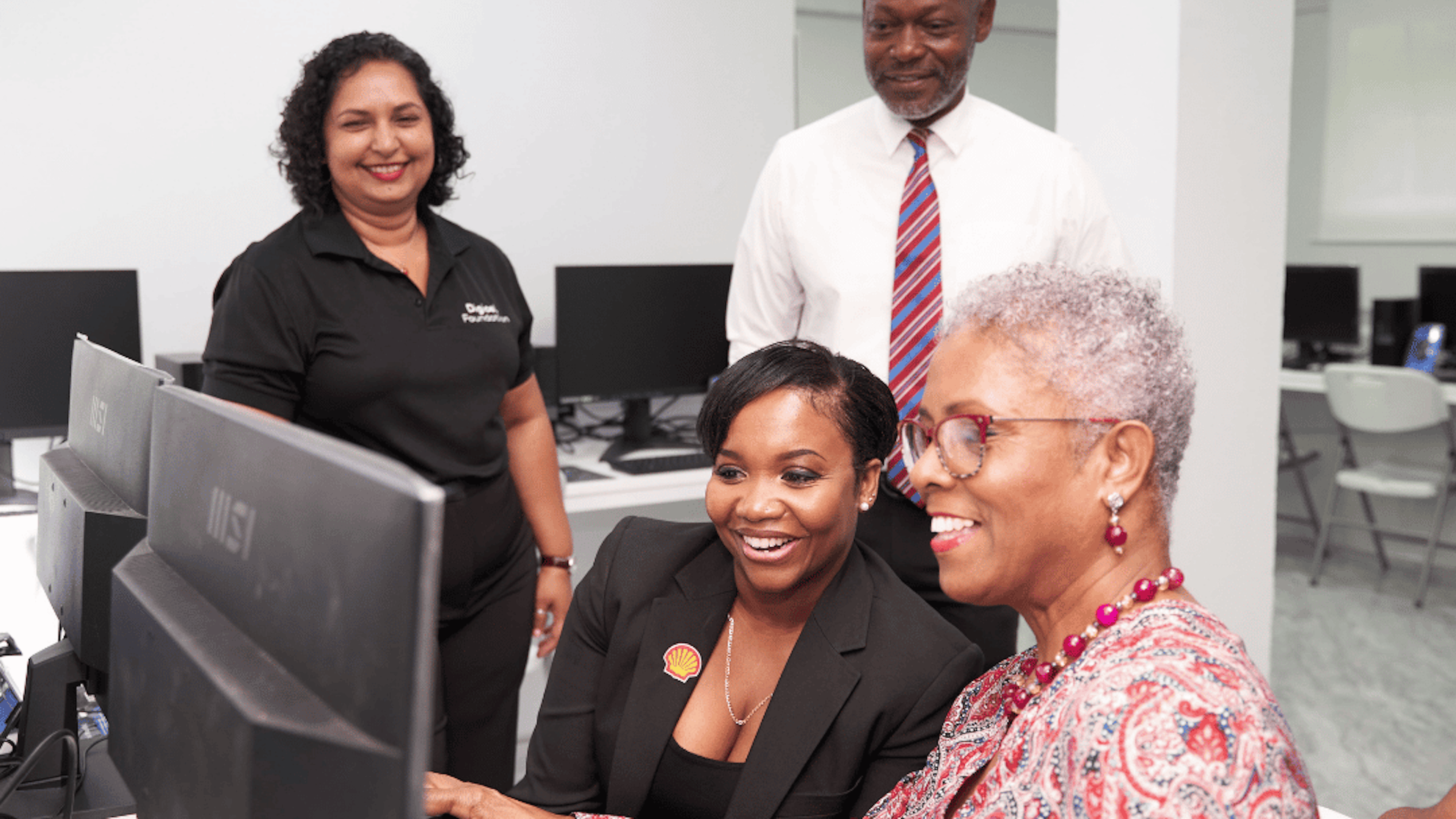 four people looking at a computer