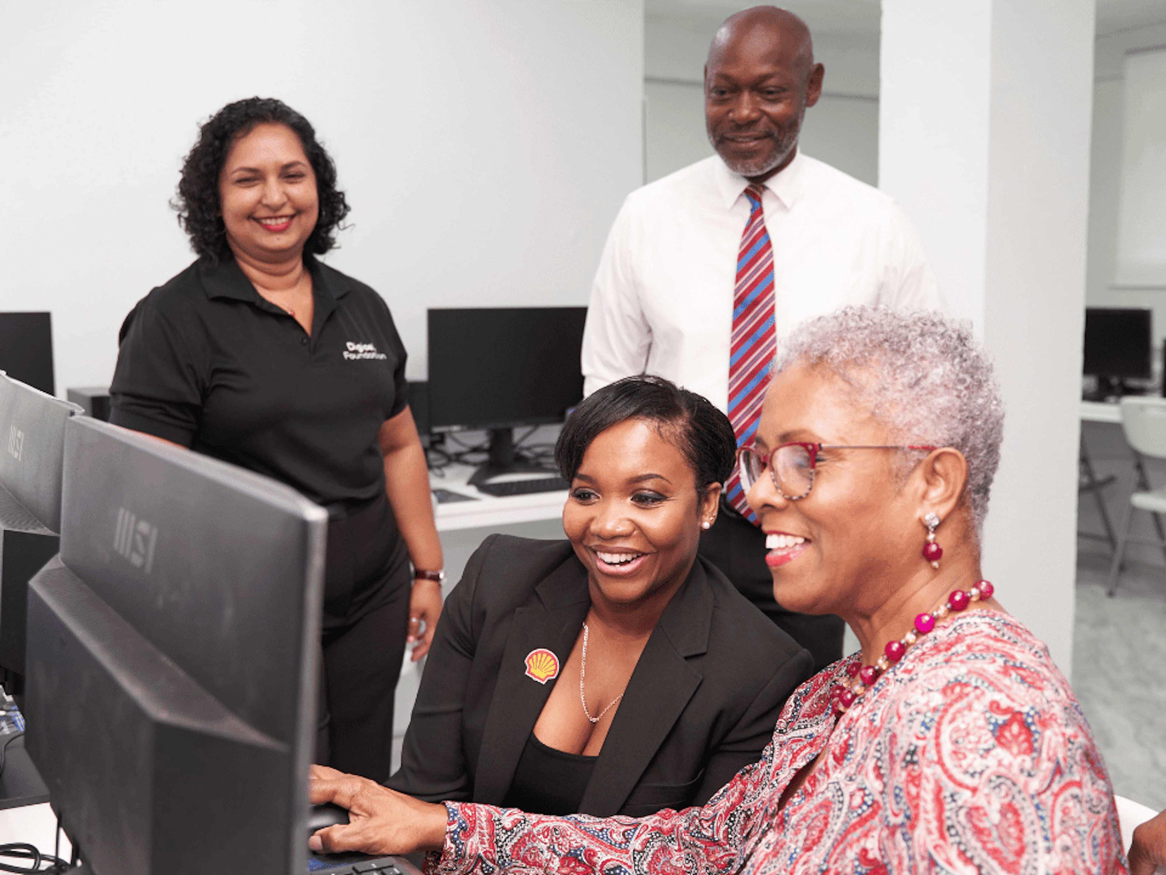 four people looking at a computer