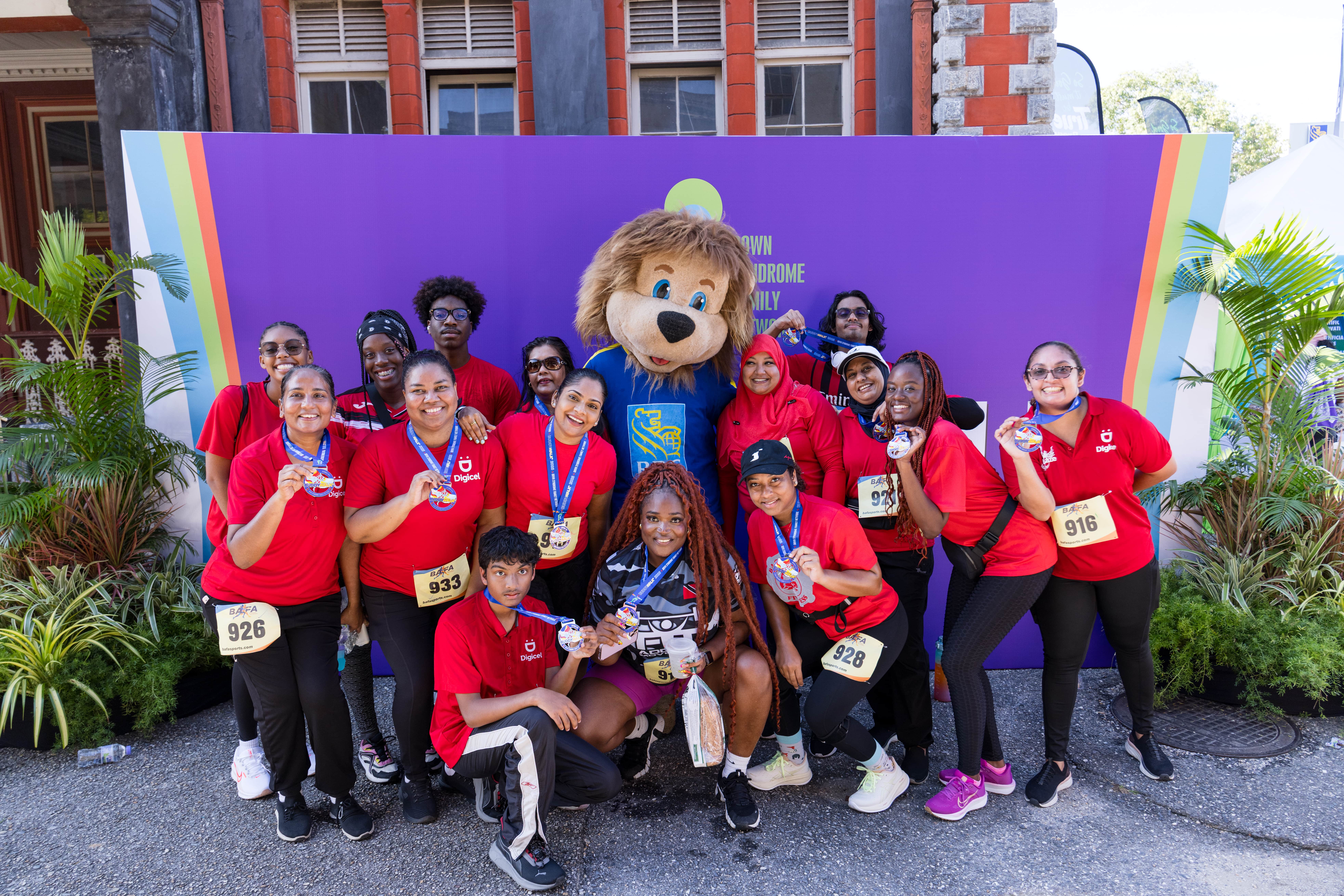 Digicel staff pose with mascot at buddy walk