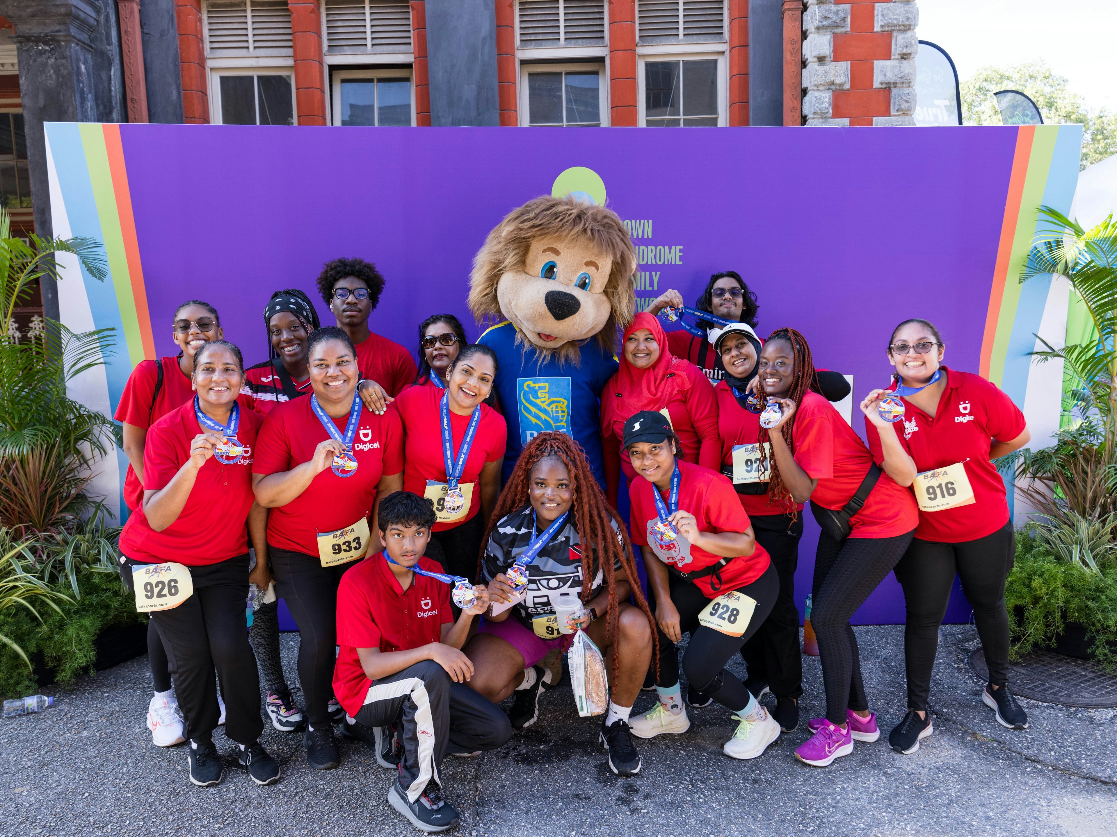 Digicel staff pose with mascot at buddy walk