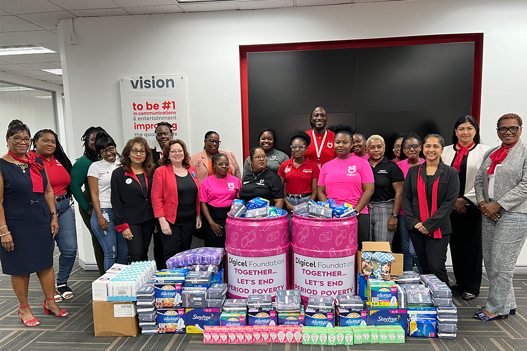 Digicel staff stand infront of donation of sanitary products