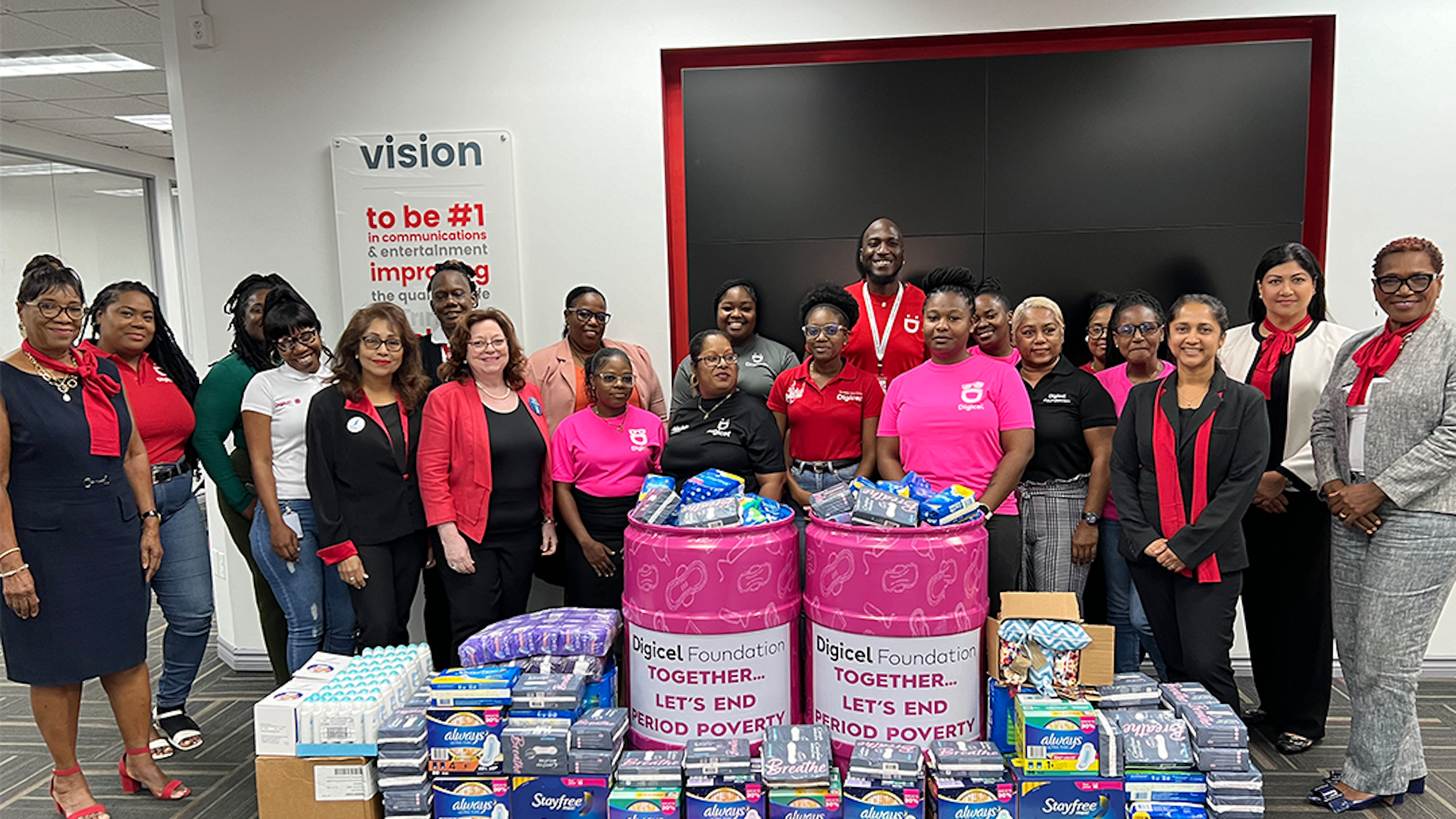 Digicel staff stand infront of donation of sanitary products