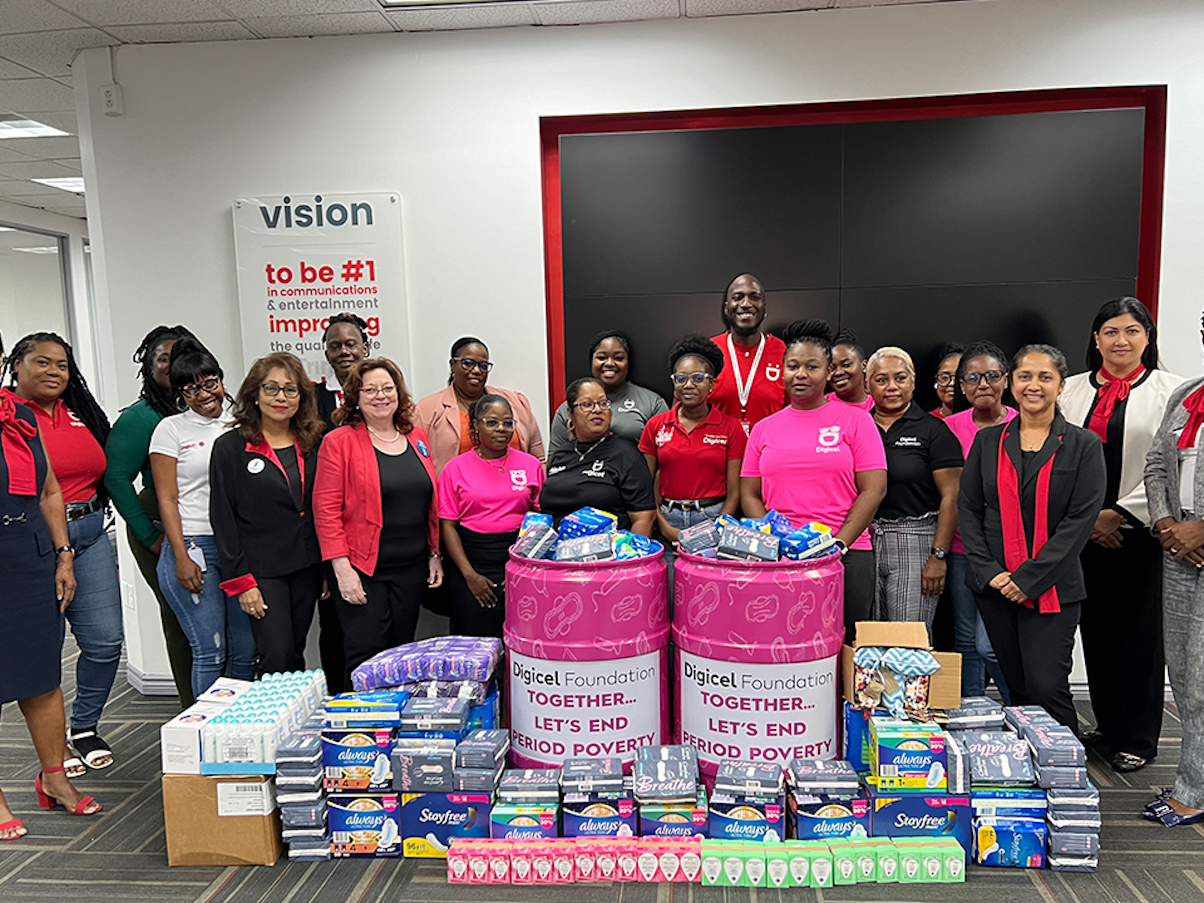 Digicel staff stand infront of donation of sanitary products