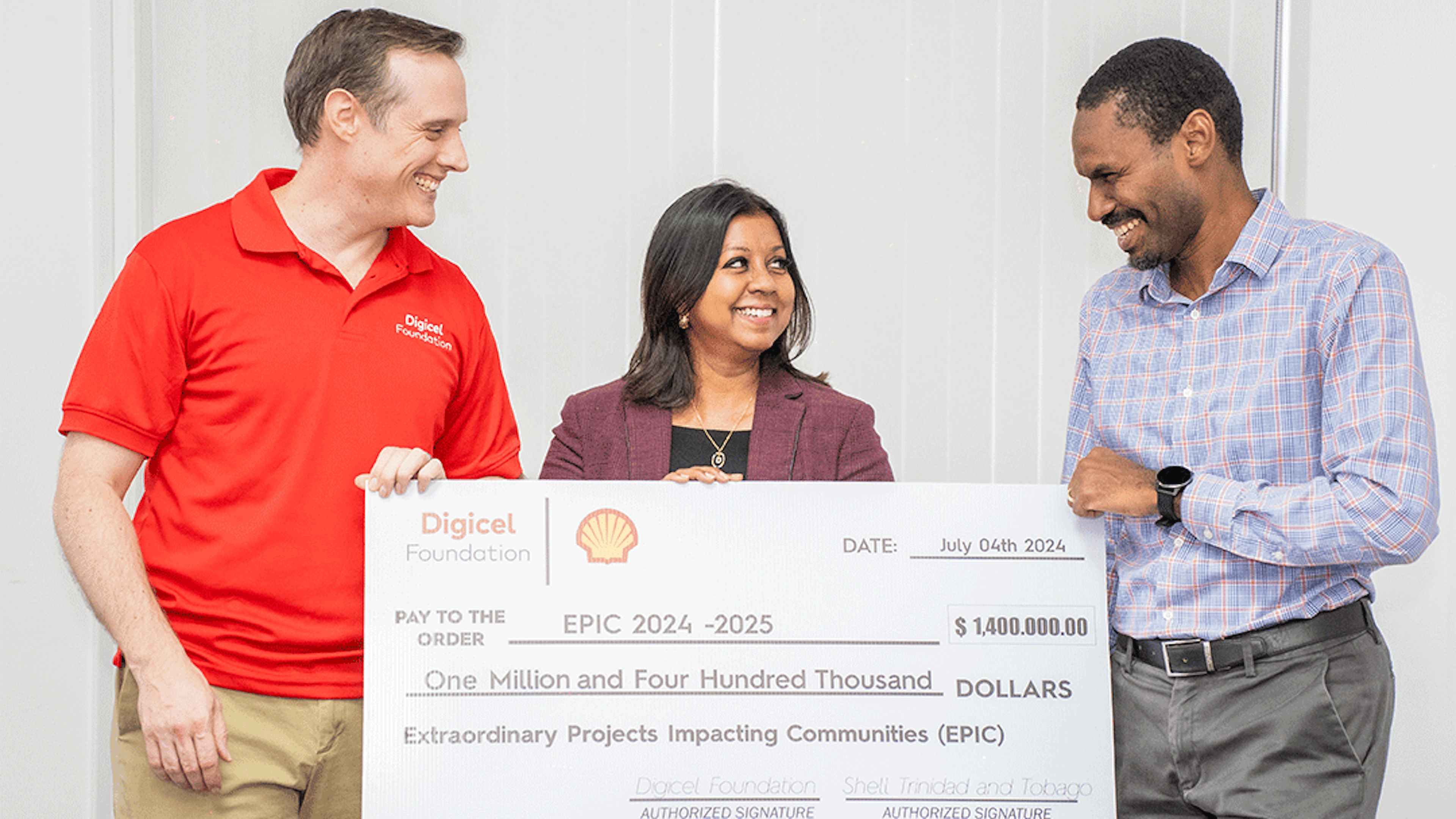 Three persons holding a big cheque
