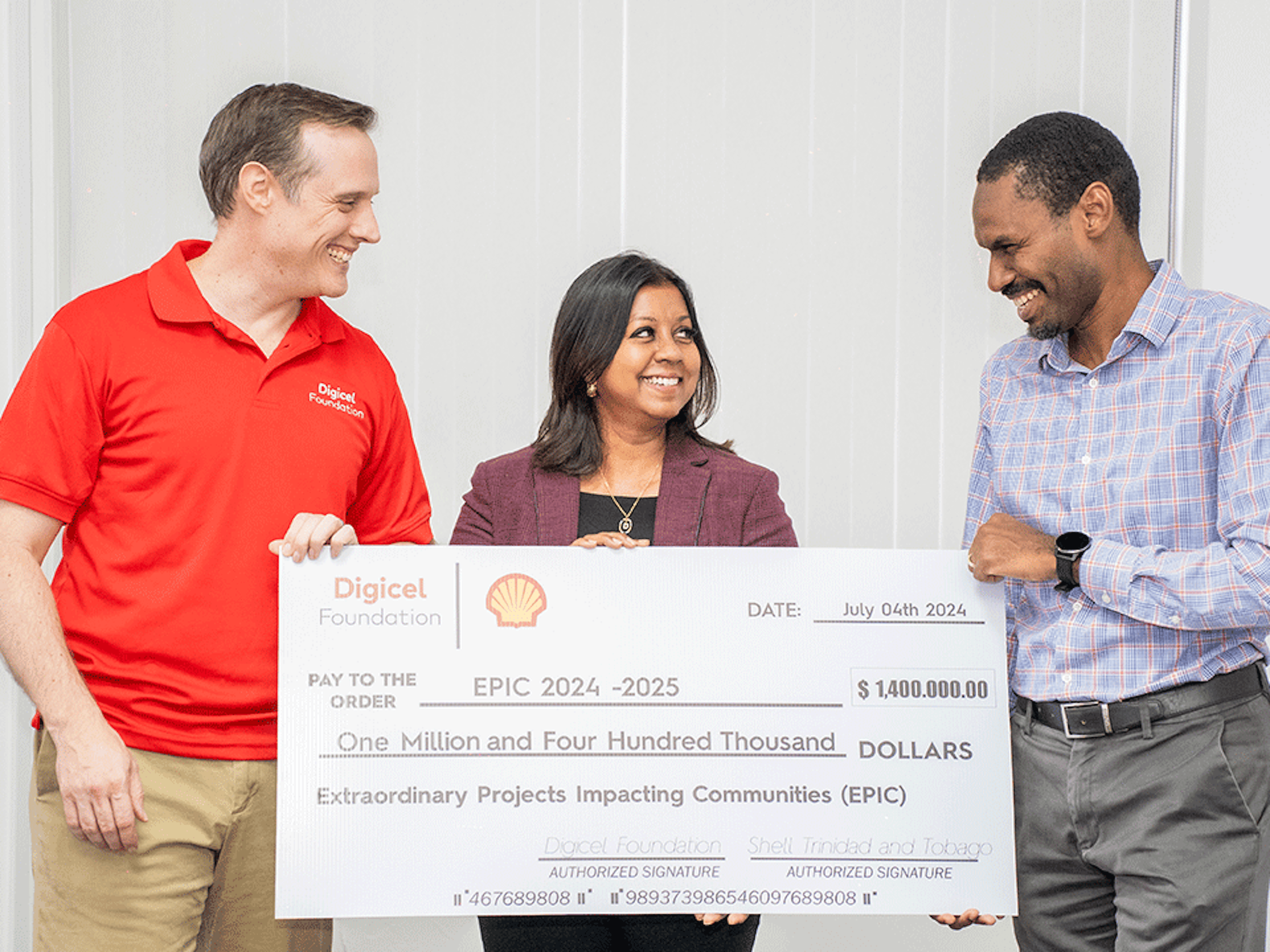 Three persons holding a big cheque