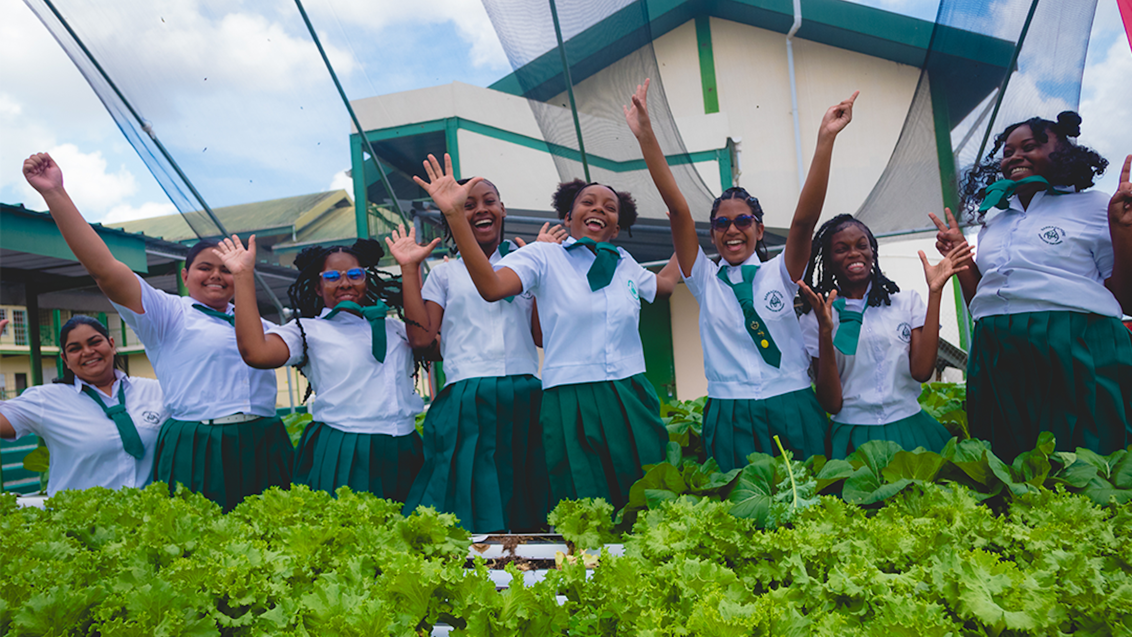 students jumping in front of hydroponics unit