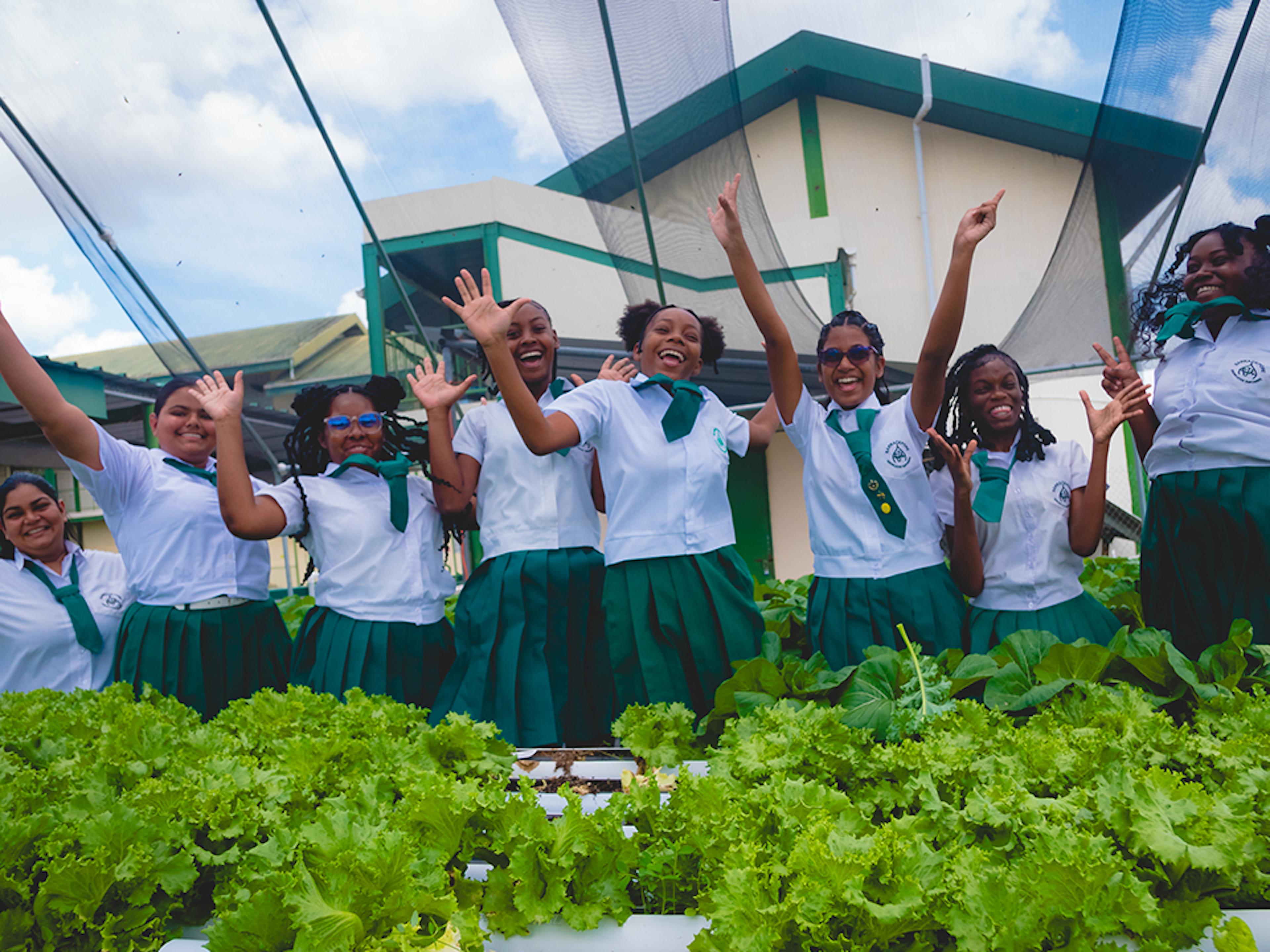 students jumping in front of hydroponics unit