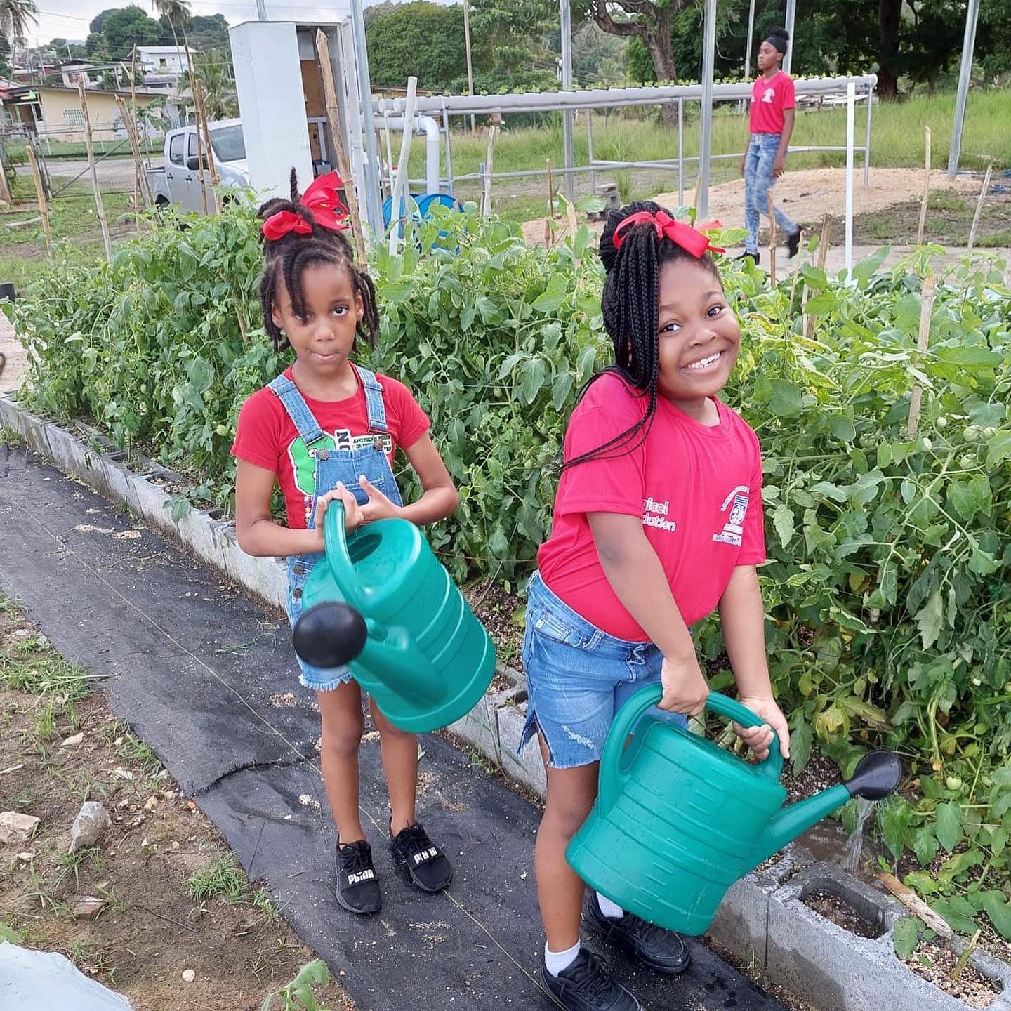 two little girls watering a garden