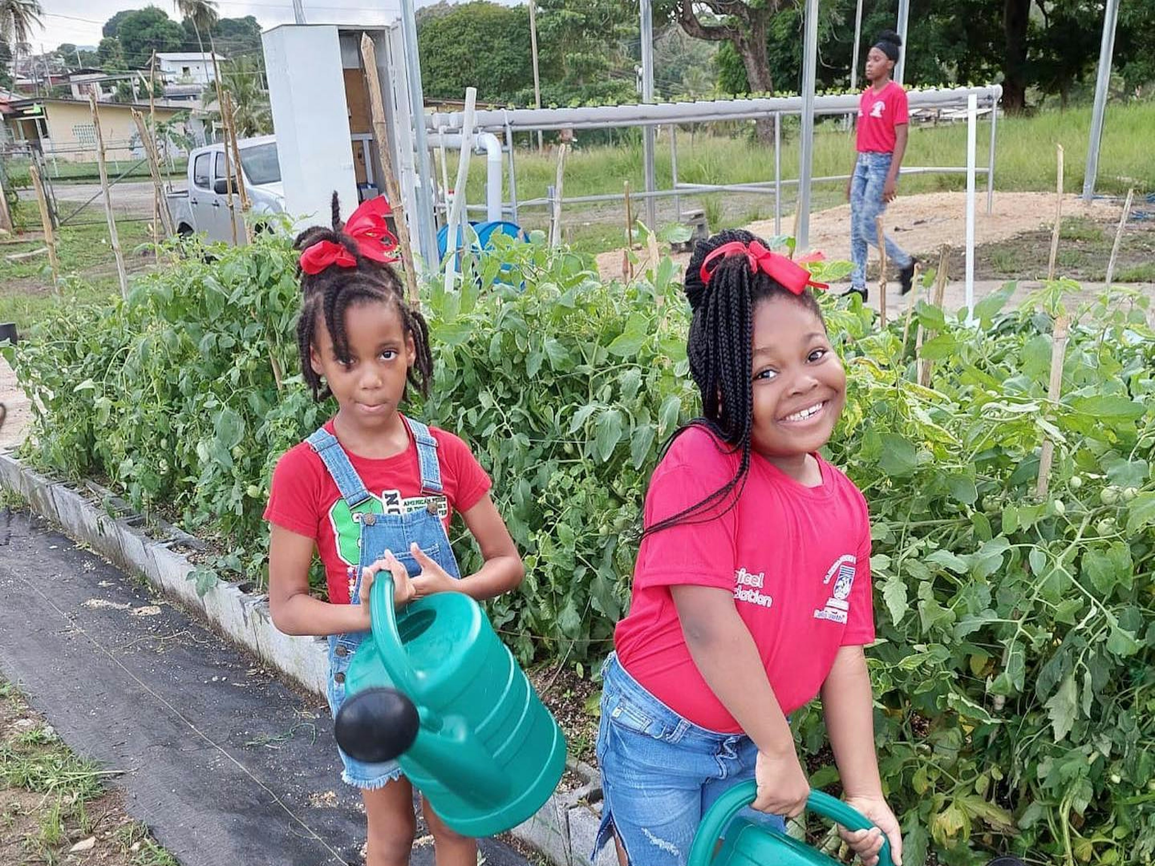 two little girls watering a garden