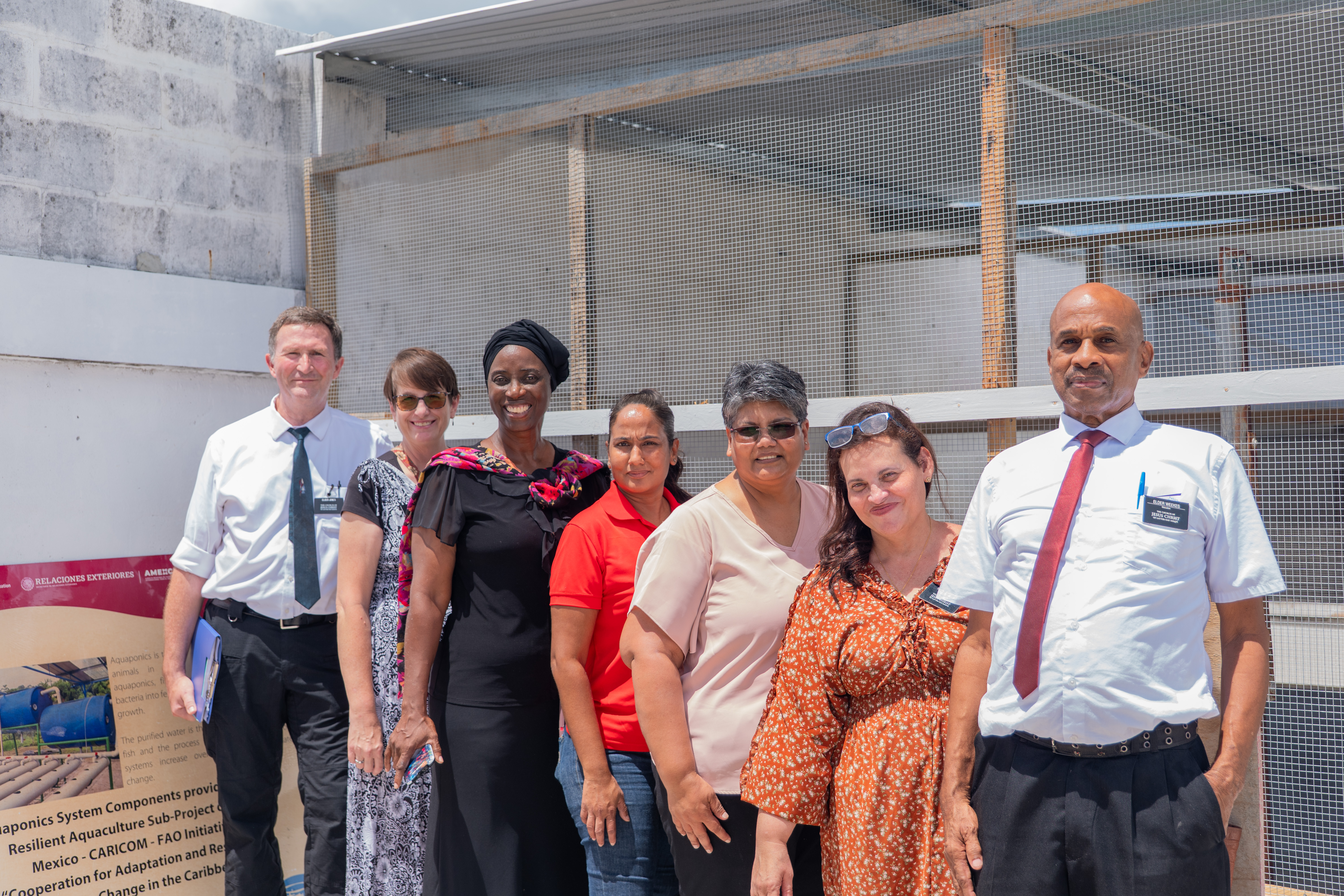 7 persons pose in front of a project site