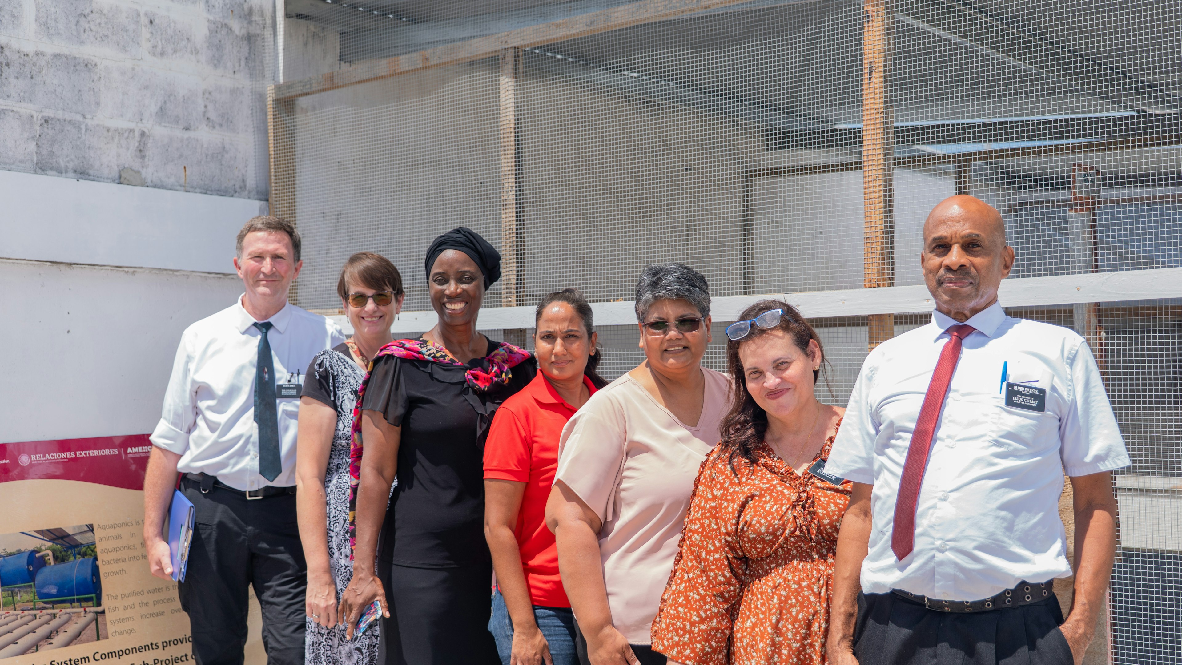 7 persons pose in front of a project site