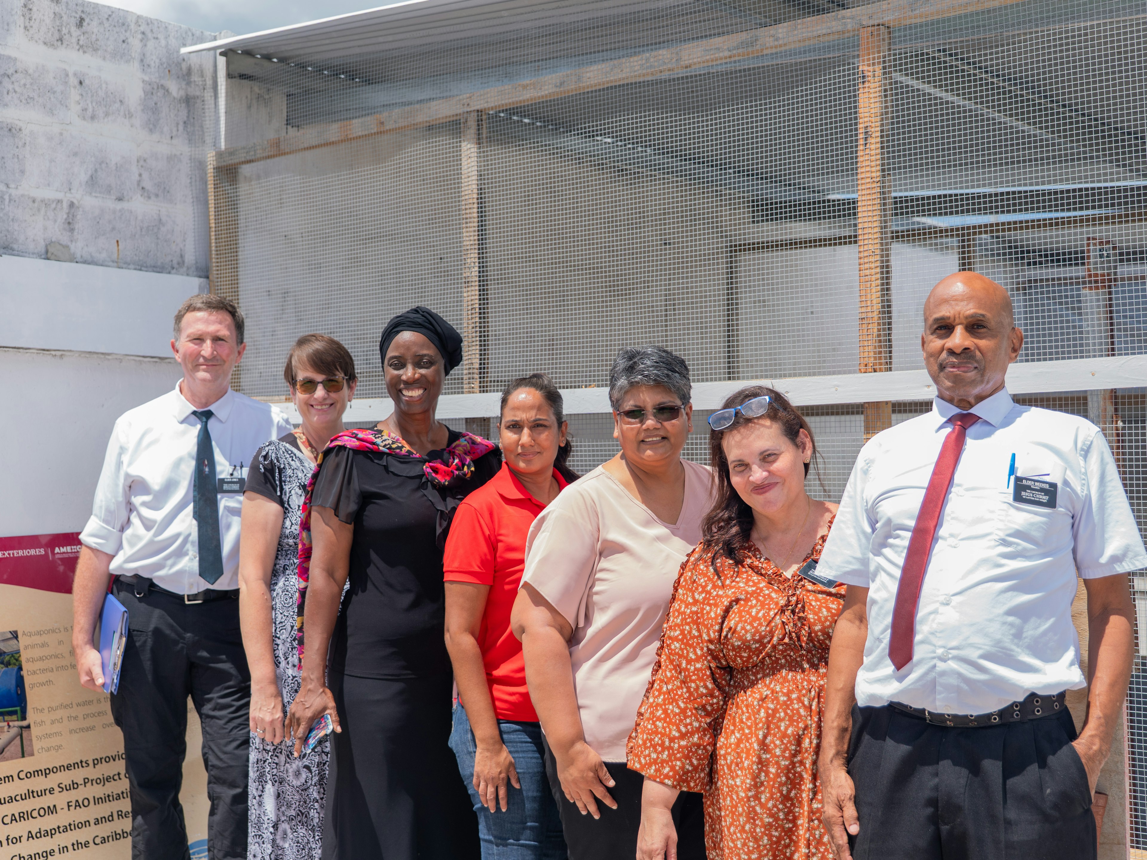 7 persons pose in front of a project site
